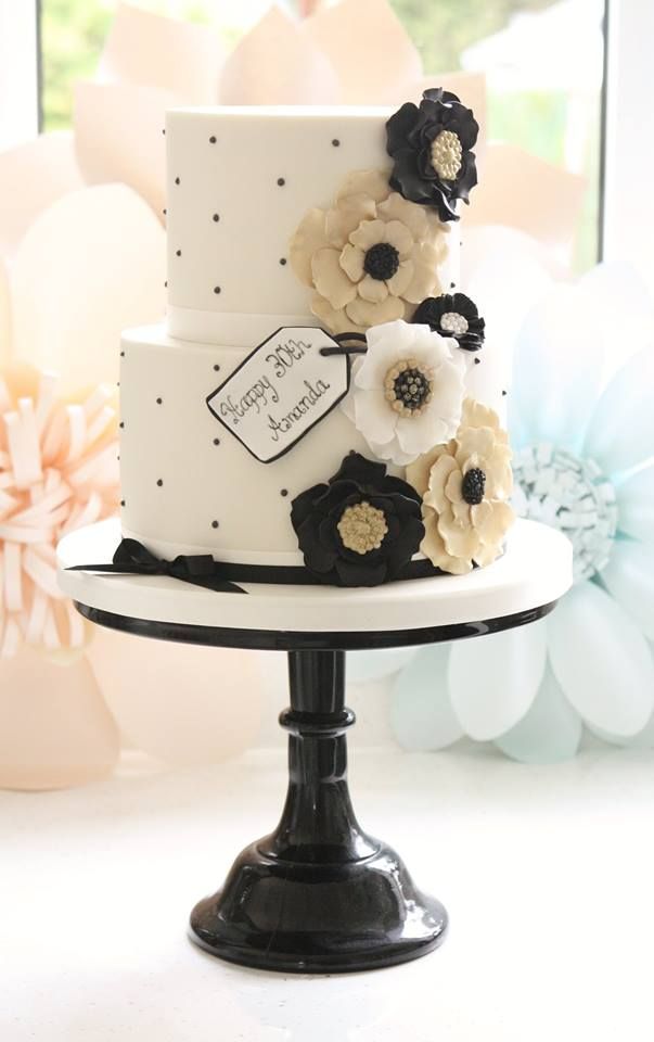 white and black wedding cake with gold flower