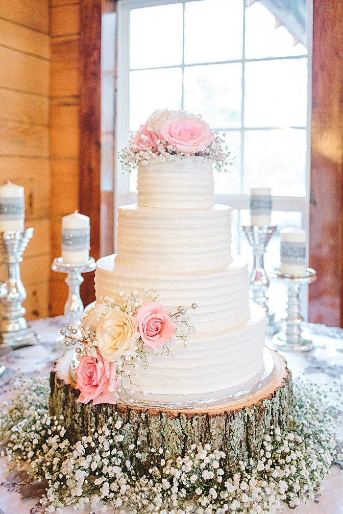 white buttercream wedding cake with tree stupm and baby's breath flowers