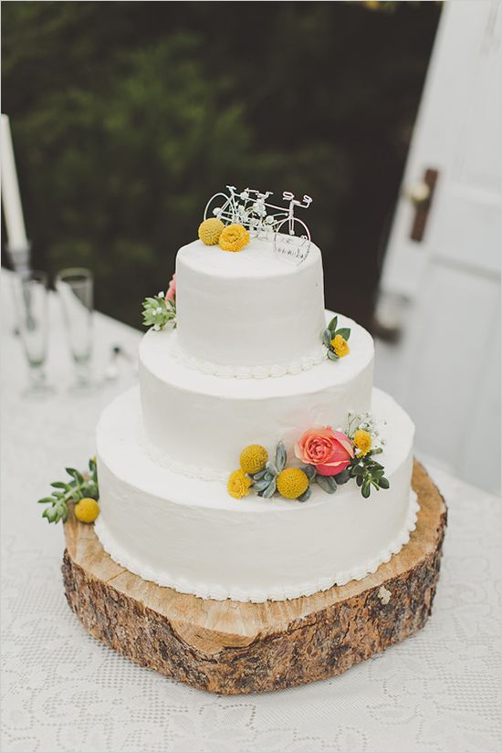 white wedding cake with billy balls and bicycle cake toppers for a bike loving couple