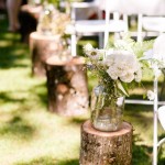 wildflowers in mason jar on tree stump woodland wedding aisle