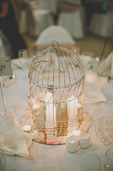 Candles in a birdcage for a wedding table centerpiece