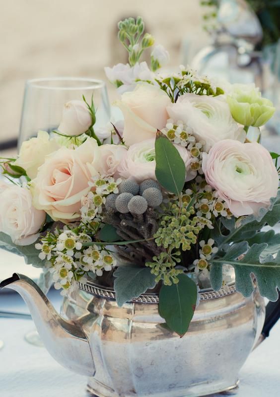 Incorporate vintage tea kettles into the centerpieces with a mixture of blue and blush-colored flowers