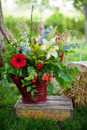 Old vintage watering cans with flowers