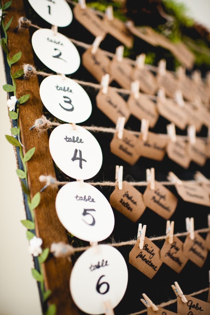 Rustic wedding escort card display with kraft paper and moss