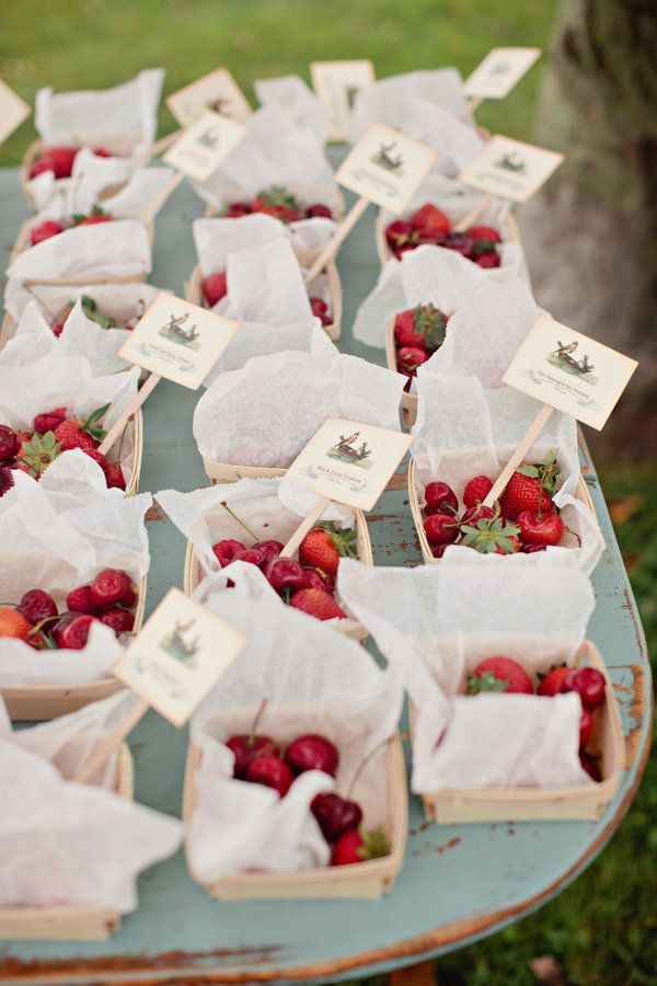a basket of berries used as seating cards for guests