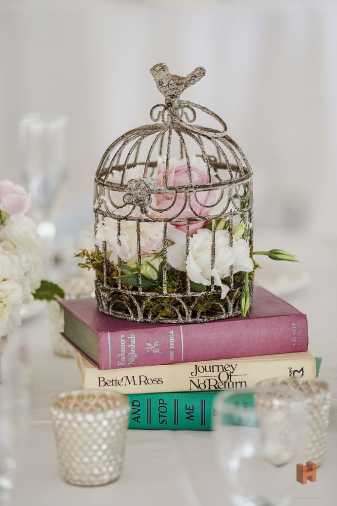 25 Amazing Birdcage Wedding Centerpieces (with Tutrial) 13 flowers in birdcage on books wedding center piece for vinatge weddings