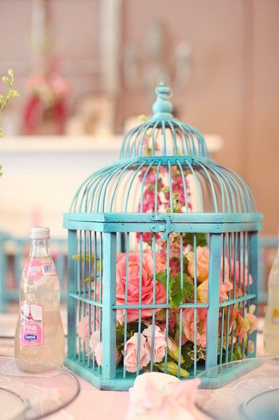 flowers of fairy lights in a lovely blue bird cage wedding centerpiece