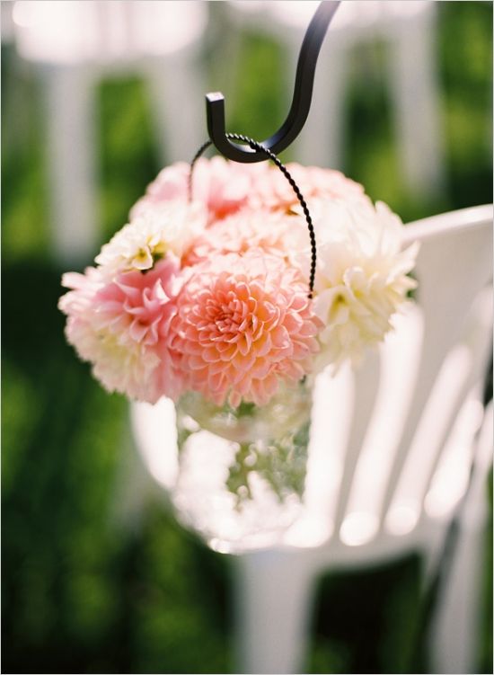 haning mason jars with pink and white florals down the aisle