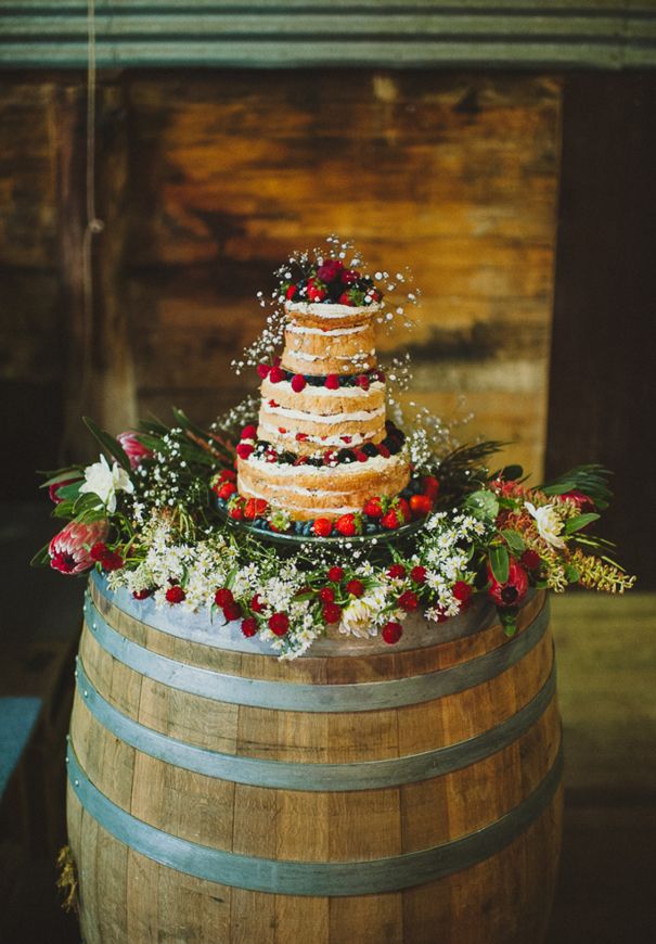 rustic naked wedding cake on wine barrel