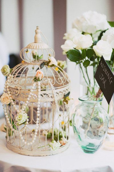 vintage birdcage with flowers and pearl wedding centerpieces