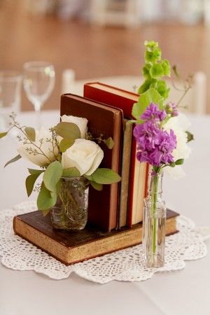 vintage books alongside small bud vases wedding centerpiece