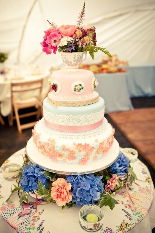 vintage inspired wedding cake with edible lace decoration and a teacup topper