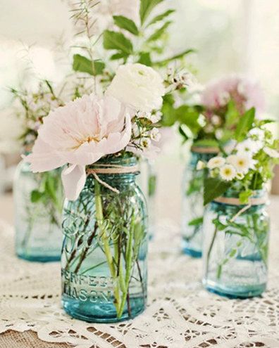 Flower arrangements in blue mason jars