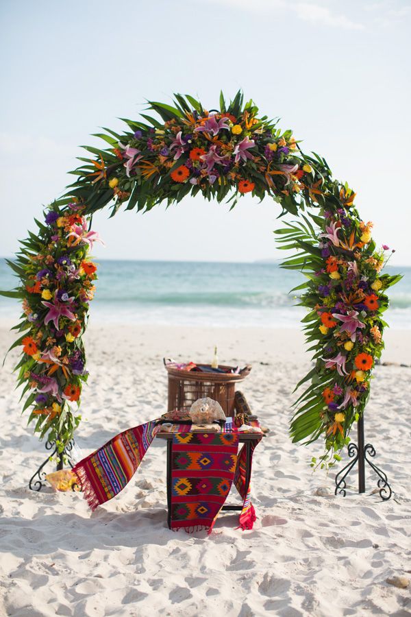 colorful flowers and mexican blankets beach wedding arch