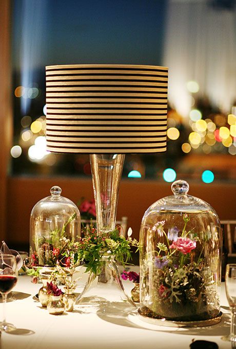 floral arrangements under glass cloches, and lamps with black and white striped shades