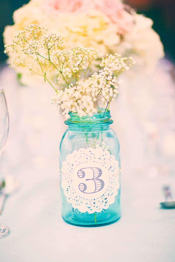 flowers in mason jar with laser cut paper wedding table number