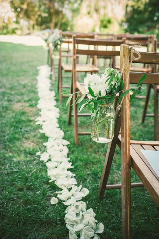 mason jar floral decorations and petals on the ground to define the aisle
