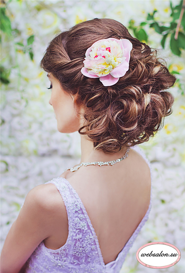 messy updo bridal hairstyle with pastel flower