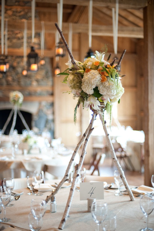 tall birch log centerpieces with white, green and yellow flowers