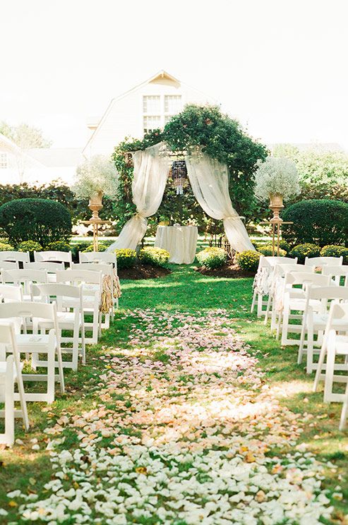 wedding aisle covered in flower petals leads to an altar