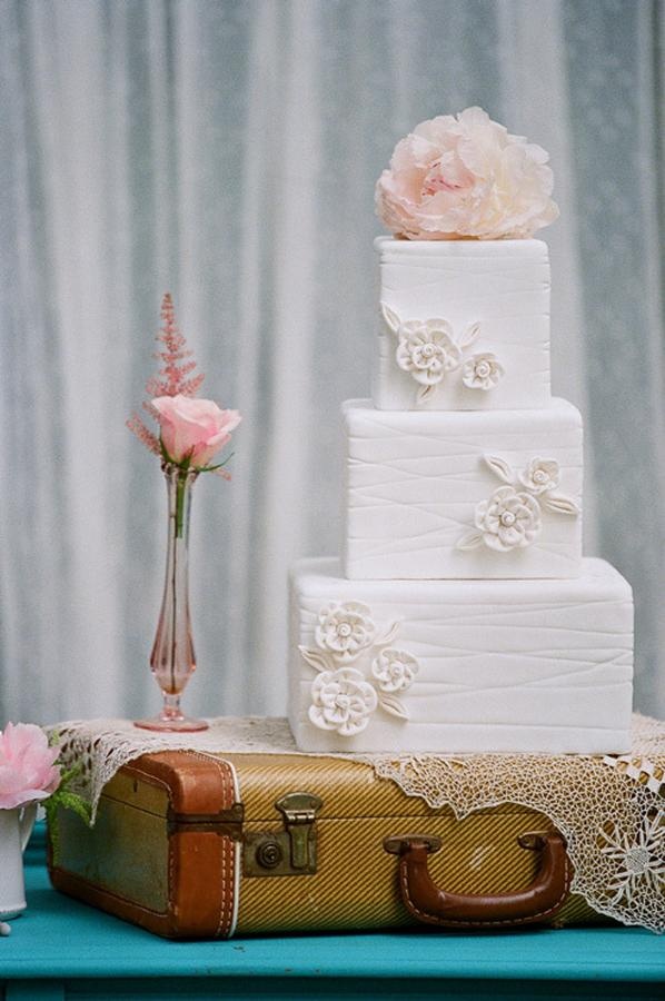 wedding cake on top of the old leather luggage