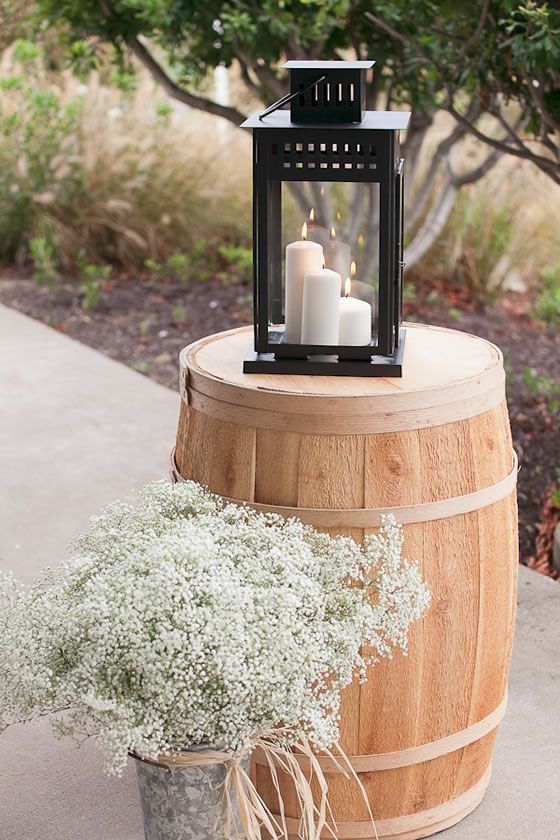 Wine barrel, candle lantern and baby's breath create a simple rustic look