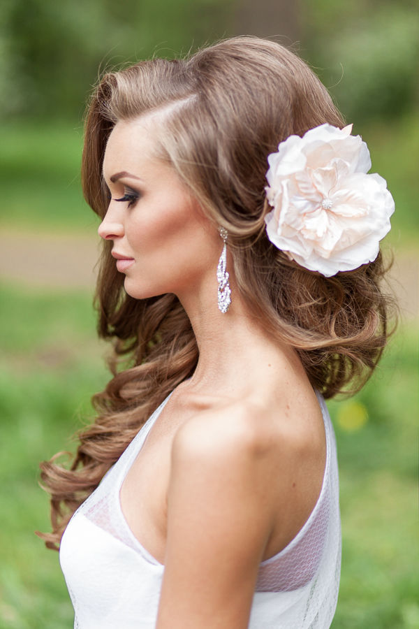 curly bridal hairstyle with blush flower