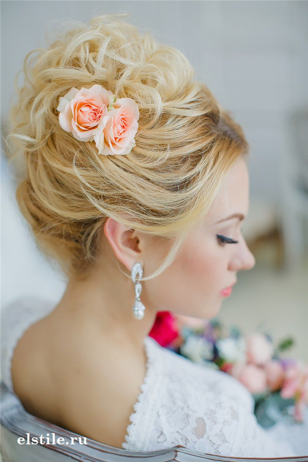 curly top knot updo hairstyle with coral roses
