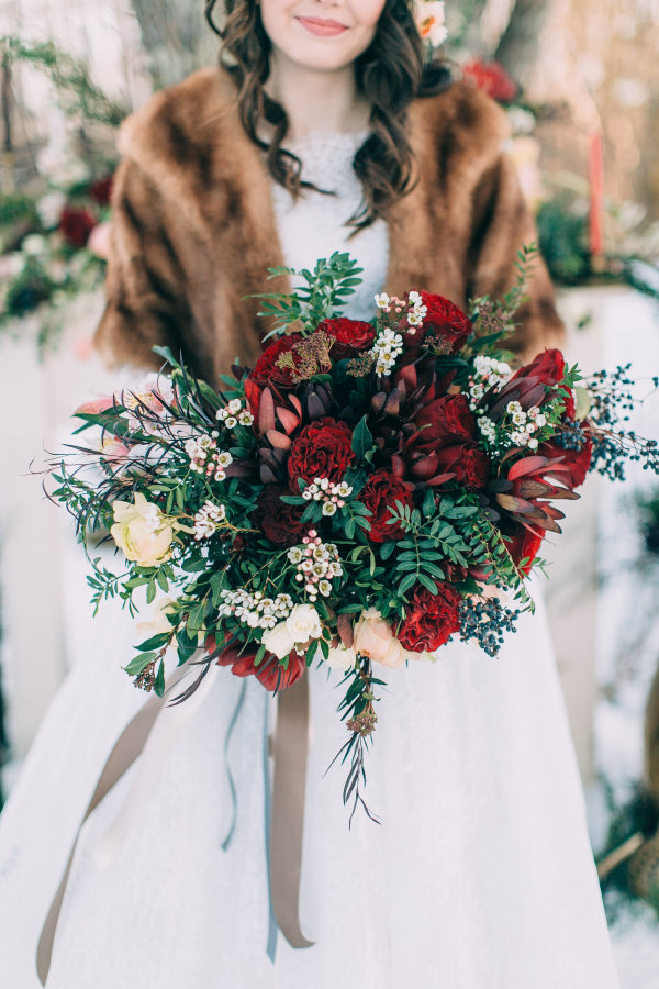dark red winter wedding bouquet and winter wedding dress