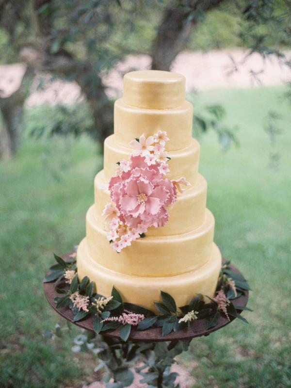 gold wedding cake with pink flowers