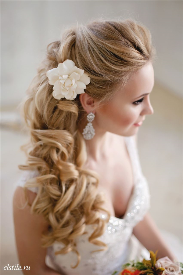 half up half down long cur;ly wedding hairstyle with flower