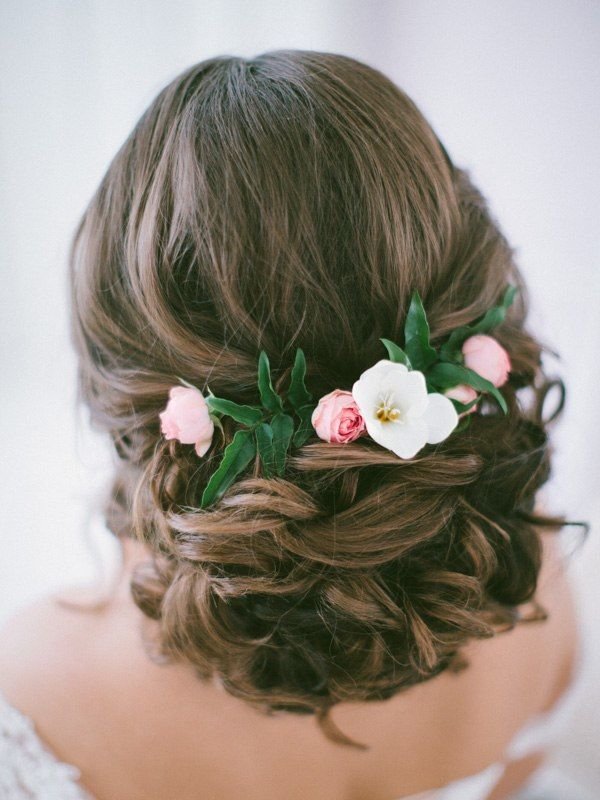 long wavy low updo hairstyle for wedding with pink flowers