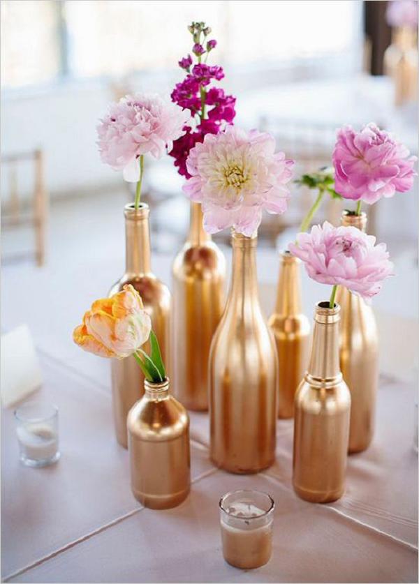 pink flowers in gold bottle wedding centerpiece