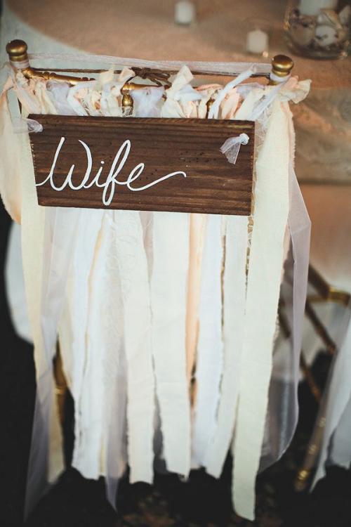 Adorable sign and decoration for the bride and groom's chairs at the reception