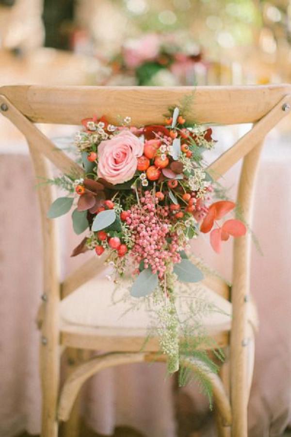 Winter wedding flowers decorate the table chairs