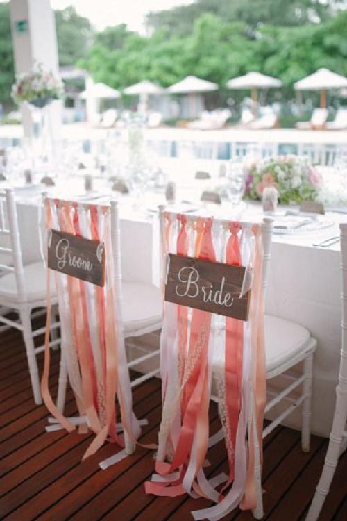 white wedding chair with coral ribbons