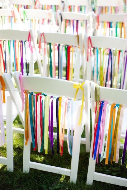 white wedding chair with rainbow chair ribbon