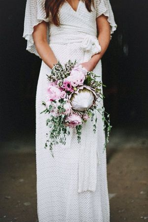 Boho wedding dress and pink protea wedding bouquet