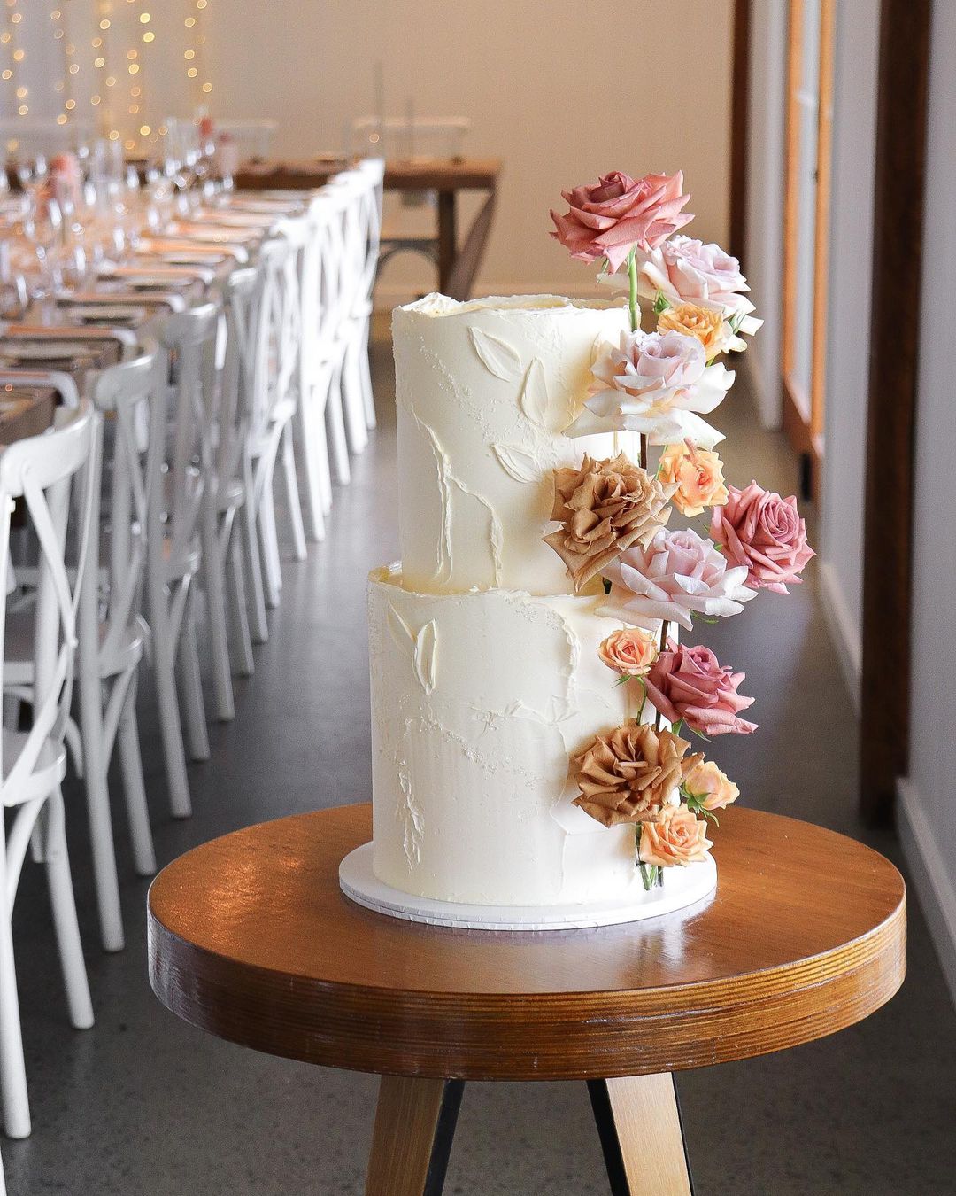 romantic two tier buttercream wedding cake with earthtone color roses via milkandhoney.cakecreative