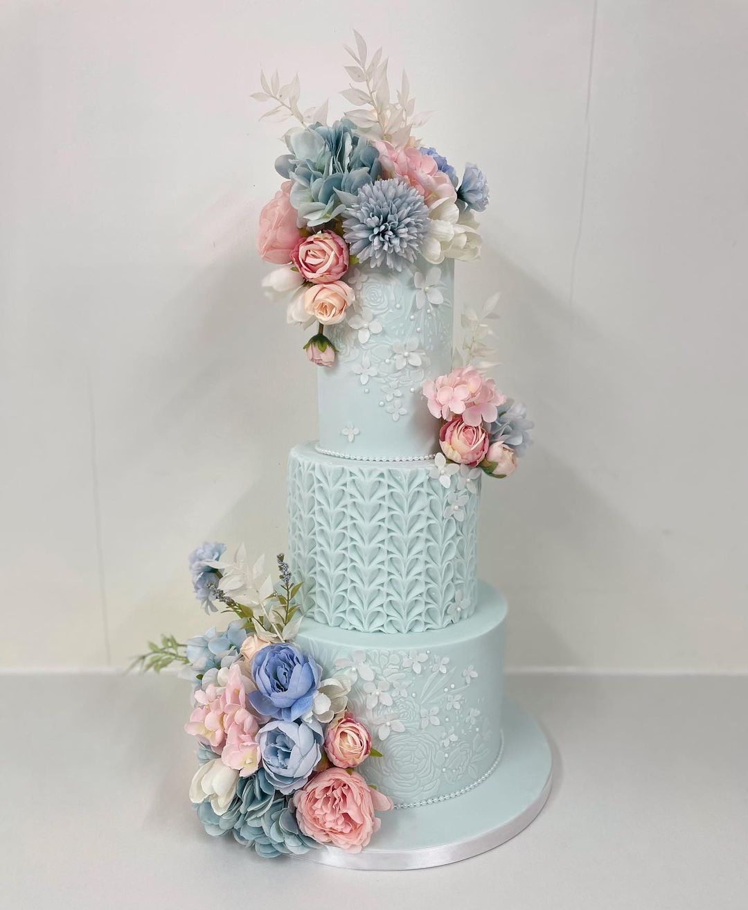 three tier mist wedding cake with colorful flowers via sweet_jeelees