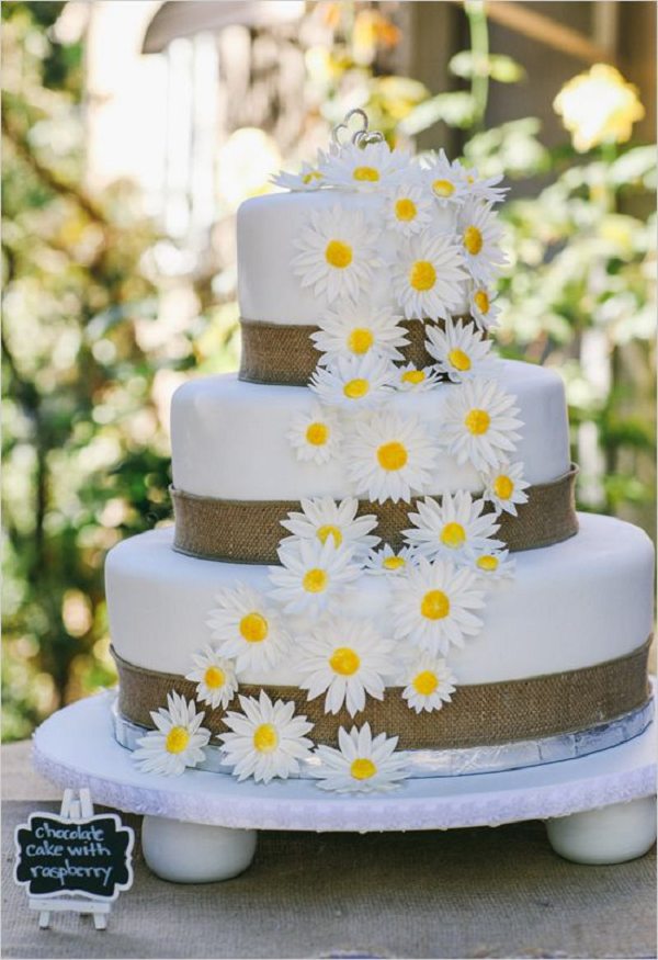 white wedding cake with burlap and flowers