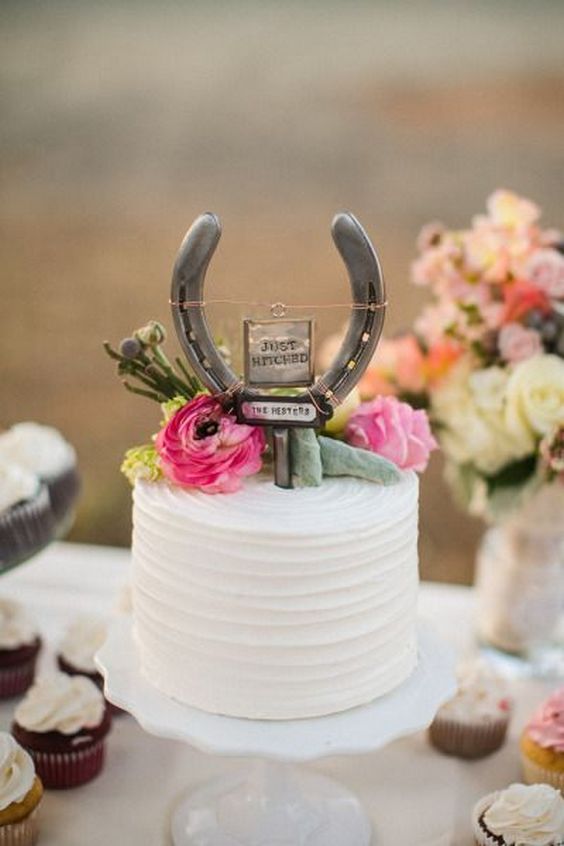Rustic wedding cake with horseshoe wedding cake topper