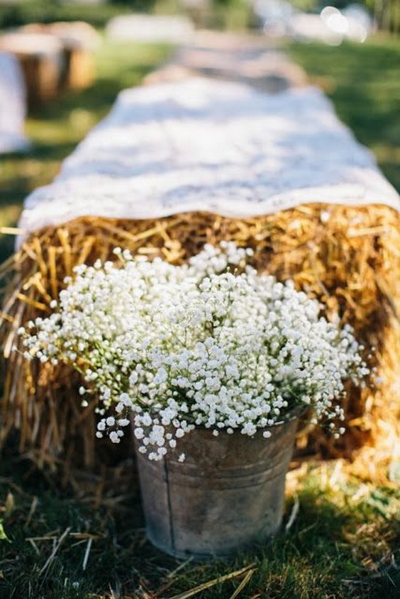 hay bales with galvanized buckets of babies breath for the aisle and ceremony seating wedding