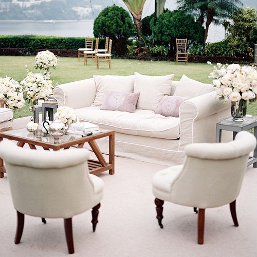outdoor lounge area with white couches and chairs
