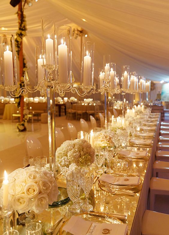 Banquet tables covered in white blooms, metallic accents and flickering candlelight, added big doses of style and glamour to the space