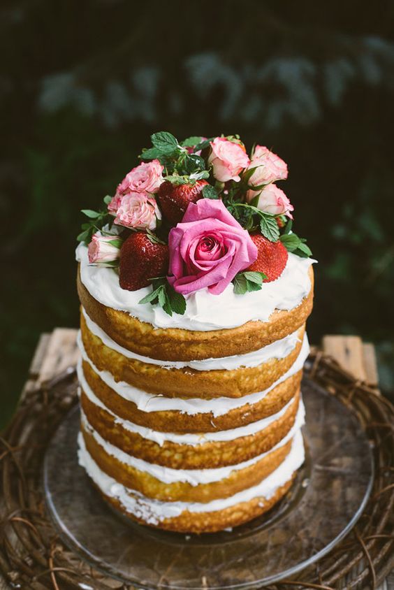 Blonde naked wedding cake topped with berries and roses
