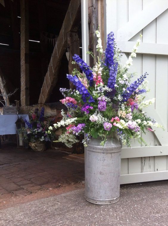 Country garden flowers arranged in milk churn