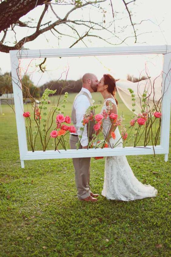 Crisp white picture frame filled with pink and orange flowers and greenery