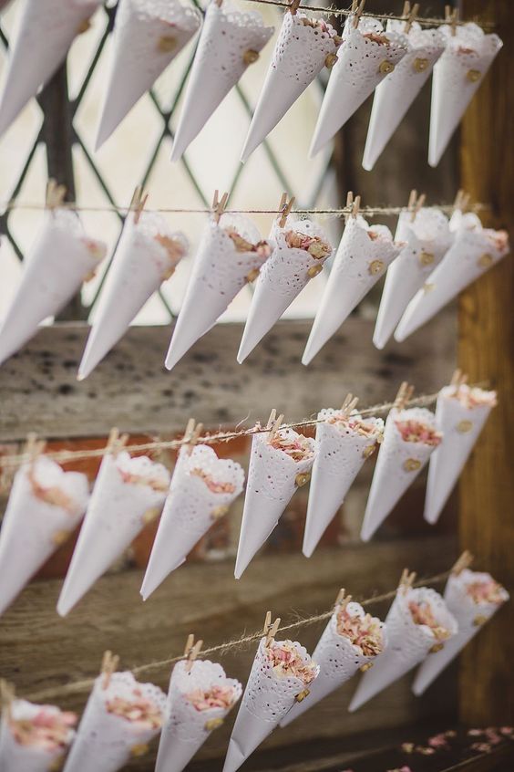 Lace doily confetti cones pegged to a wooden frame