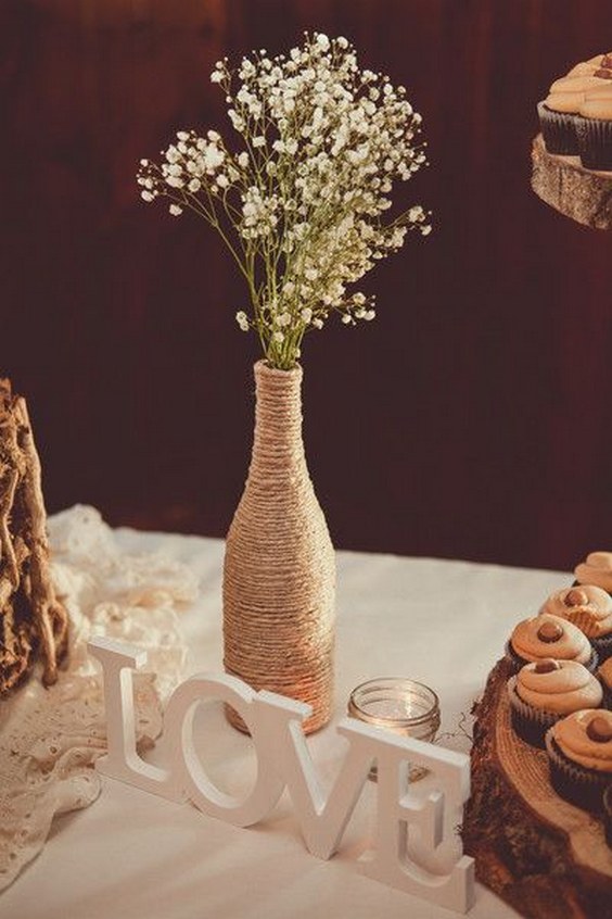 Rustic wedding centerpiece idea - wine bottles wrapped in twine and filled with baby's breath